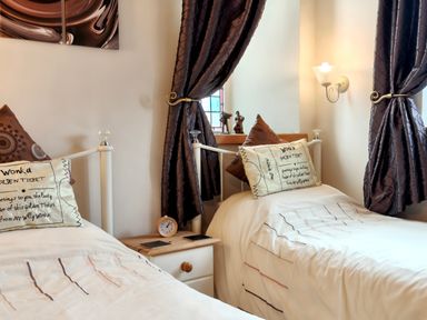 A bedroom with two beds and decorative elements at Kaber Chapel in Kaber near Kirby Stephen