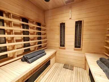 A sauna with wooden benches and rolled towels at Kaber Chapel near Kirby Stephen