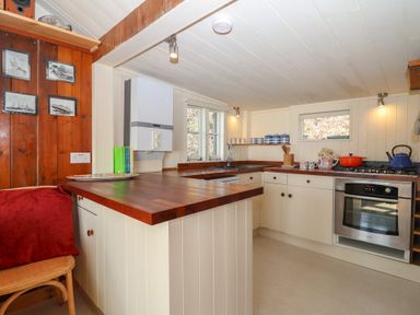 A kitchen with a countertop, stove, and sink at The Cabin in 