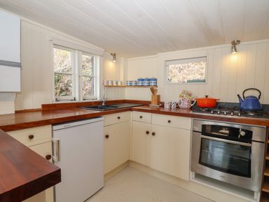 A kitchen with a sink, refrigerator, and oven at The Cabin 