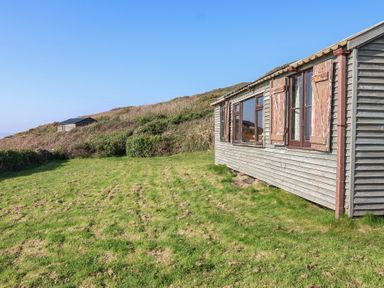 An outdoor area with a cabin and grass at The Cabin in 