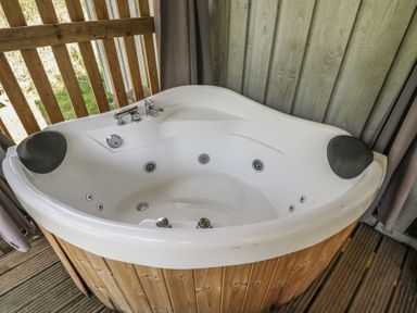 A hot tub with a faucet and spout at Owls Nest Lodge South Molton