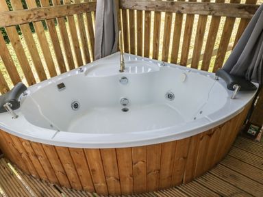A hot tub with wooden paneling in an outdoor area at Robins Nest Lodge in South Molton