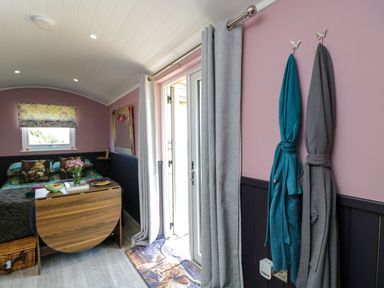 A living room with a bed and a door at Hares Hideaway Shepherd's Hut in South Molton