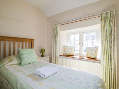 A bedroom with a bed and window at The Farmhouse in Keswick