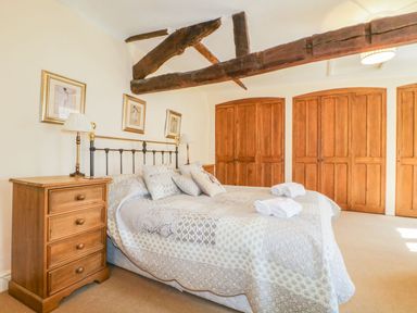 A bedroom with a bed and wardrobe at The Farmhouse in Keswick
