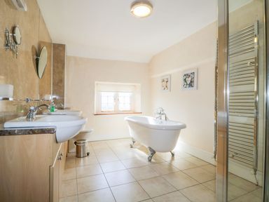 A bathroom with a bathtub and sinks at The Farmhouse in Keswick