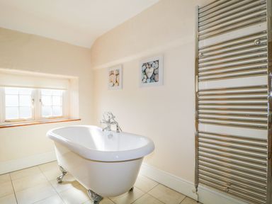 A bathroom with a bathtub and towel radiator at The Farmhouse in Keswick