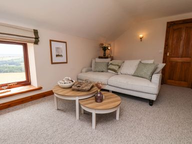 A snug with a sofa and coffee table at Swallow Cottage in Lealholm