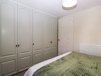 A bedroom with a wardrobe and a bed at Bobbin Nook