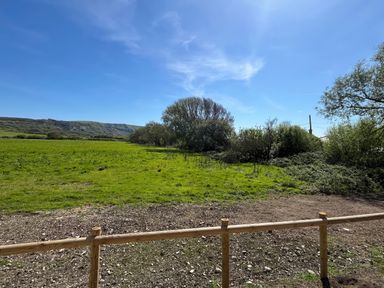 A field with trees and hills at The Orchard in Ringstead