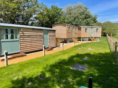 Three wooden caravans in an outdoor area at The Orchard in Ringstead