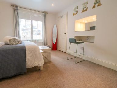 A bedroom with a bed, desk, and mirror at The Hideaway in Whitby