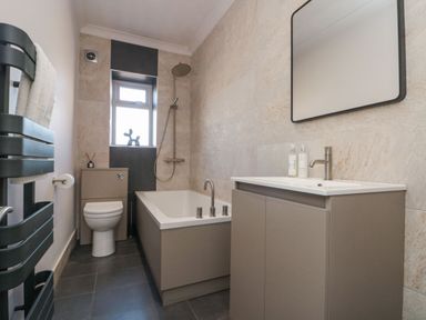 A bathroom with a bathtub, toilet, and sink at Cuckoo's Nest in Whitby
