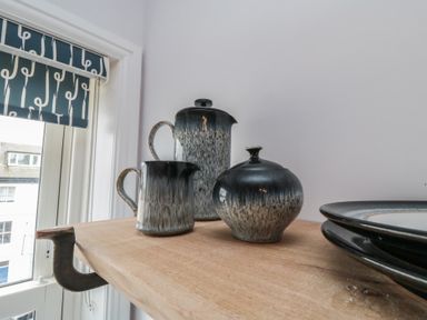 A teapot, milk jug, and sugar bowl on a wooden shelf at Cuckoo's Nest in Whitby