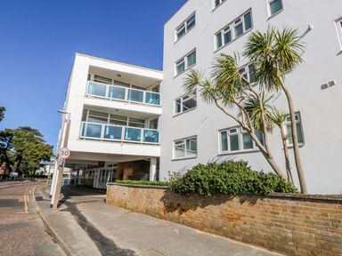 A building with balconies and palm trees at Flat 17 Golden Gates in Poole