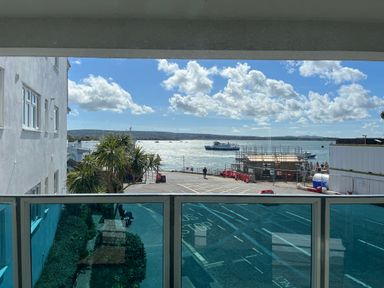 A view of the sea with a boat and construction site at Flat 17 Golden Gates Sandbanks