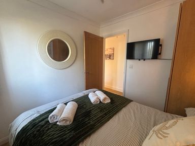 A bedroom with a bed and a television at Seaview in Pakefield