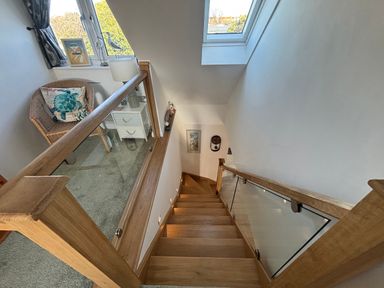 A staircase with a window and a chair at Seaview in Pakefield