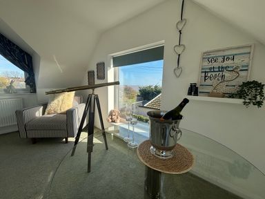 A snug with telescope and wine bottle at Seaview in Pakefield