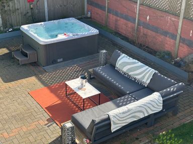 A garden with a hot tub and outdoor seating at Seaview in Pakefield