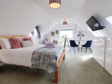 A bedroom with a bed and seating area at Seaview in Pakefield