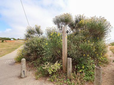 A footpath sign near bushes and a path at Seaview in Pakefield