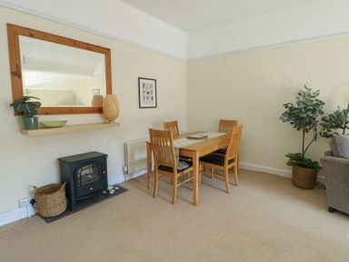 A dining room with a table and chairs at Castle Gardens Apartment in Beaumaris