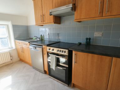 A kitchen with cabinets and appliances at Castle Gardens Apartment Beaumaris