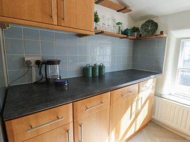 A kitchen with cabinets, countertop, kettle, and canisters at Castle Gardens Apartment Beaumaris