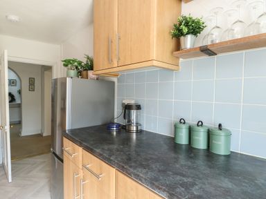 A kitchen with a refrigerator and canisters at Castle Gardens Apartment Beaumaris
