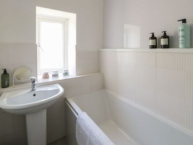 A bathroom with a sink and tub at Castle Gardens Apartment Beaumaris
