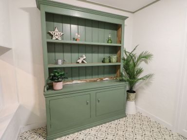 A shelf with decorative items and a plant at Castle Gardens Apartment Beaumaris