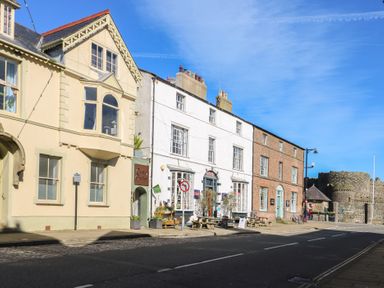 A street view of buildings and outdoor seating at Castle Gardens Apartment in Beaumaris
