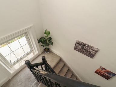 A stairway with carpet and window at Sugar Loft in Silloth