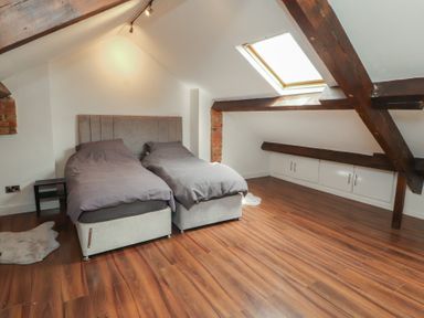 A bedroom with two beds and a skylight at Sugar Loft in Silloth