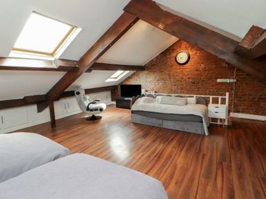 An attic with a bed and sofa at Sugar Loft in Silloth