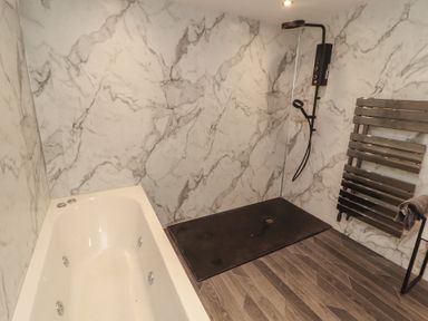A bathroom with a bathtub and shower at Sugar Loft in Silloth