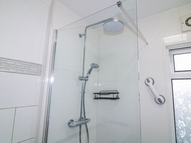 A shower with glass door and fixtures at The Nest Lodge 55 Grantham