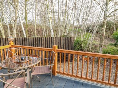 An outdoor patio with a table and chairs at The Nest Lodge 55 Grantham