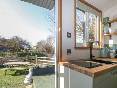 A kitchen with a window and stove at Salt Haven Shepards Hut in Pevensey
