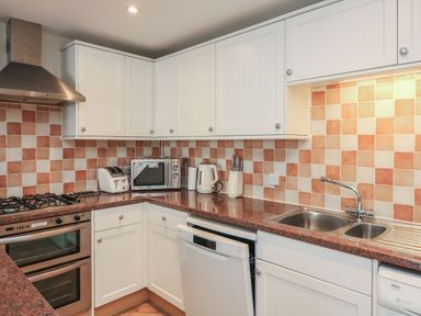 A kitchen with appliances and cabinets at 6 Dartmouth House in Dartmouth