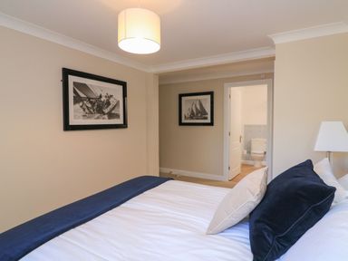 A bedroom with a bed and artwork on the wall at 6 Dartmouth House in Dartmouth