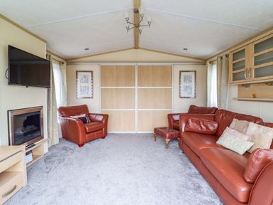 A living room with a television and fireplace at Pemberton Knightsbridge in Morfa Bychan