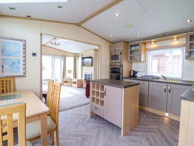 A kitchen with a dining table and appliances at Pemberton Knightsbridge in Morfa Bychan