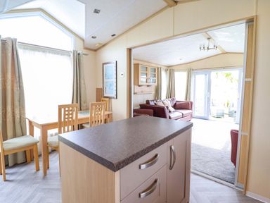 A living room with a sofa and dining area at Pemberton Knightsbridge in Morfa Bychan