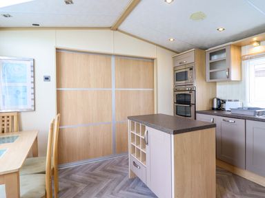 A kitchen with a table and chairs at Pemberton Knightsbridge in Morfa Bychan