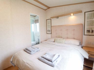 A bedroom with a bed and towels on the bed at Pemberton Knightsbridge in Morfa Bychan