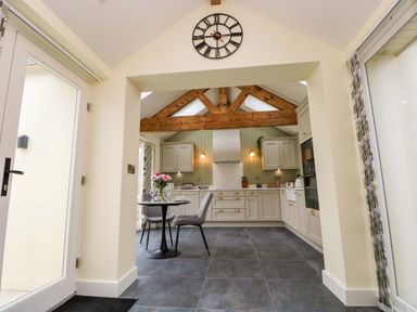 A kitchen with a table and chairs at Dairy Cottage in Oxwich