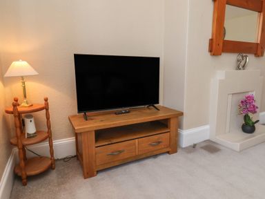 A living room with a television and a lamp at Time Out in Whitby